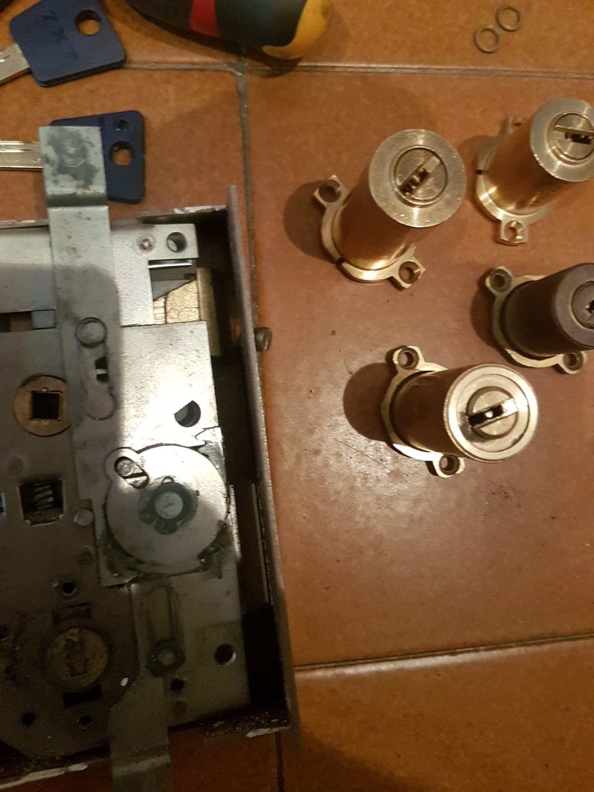 Cerradura de seguridad desmontada junto a bombines nuevos de latón