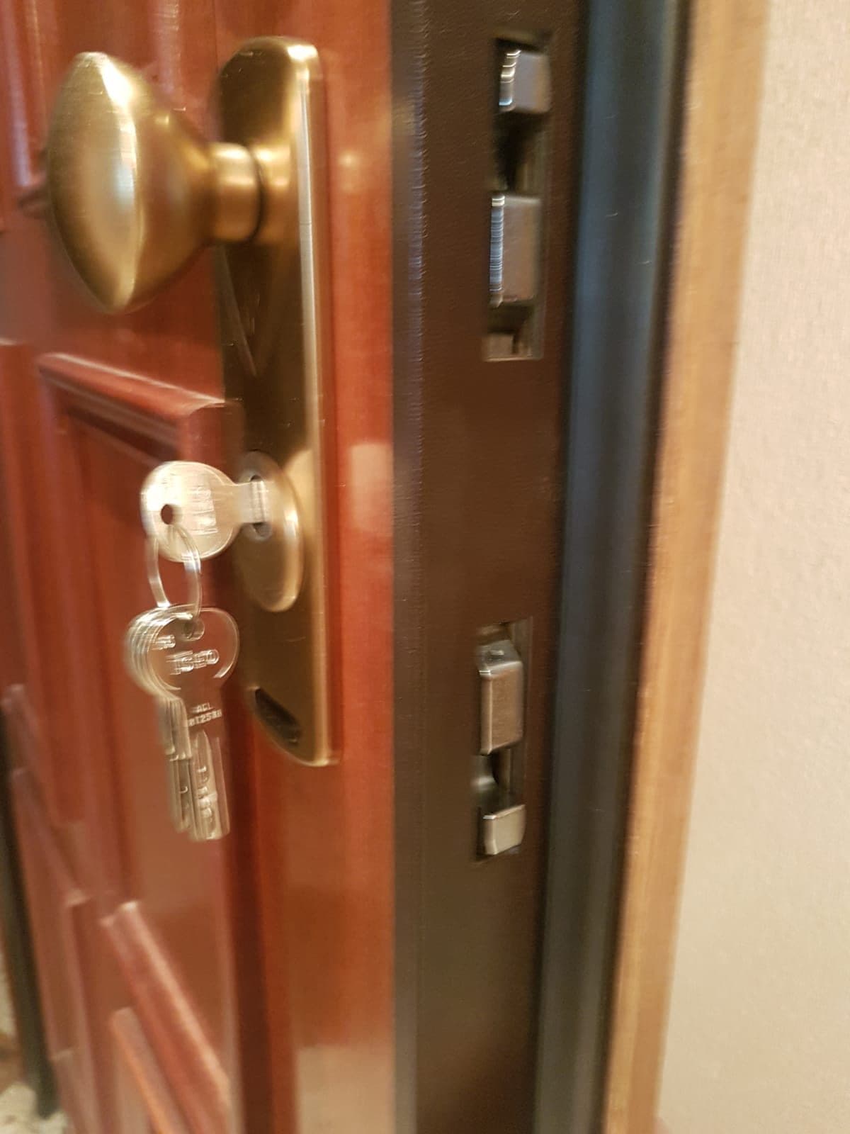 Pomo de latón y cerradura con la llave puesta en una puerta de madera